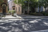 an empty street that leads to two old buildings on both sides and has a bench in front of the sidewalk