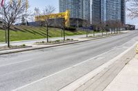 empty street in a city with high rise building behind it, and construction equipment laying on the side of the road