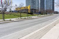 empty street in a city with high rise building behind it, and construction equipment laying on the side of the road