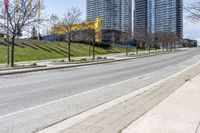 empty street in a city with high rise building behind it, and construction equipment laying on the side of the road