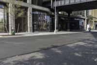 an empty street under a bridge that connects two buildings to the sidewalk and a sidewalk