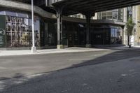 an empty street under a bridge that connects two buildings to the sidewalk and a sidewalk