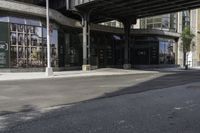 an empty street under a bridge that connects two buildings to the sidewalk and a sidewalk