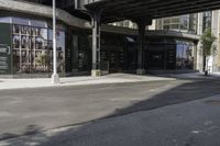 an empty street under a bridge that connects two buildings to the sidewalk and a sidewalk