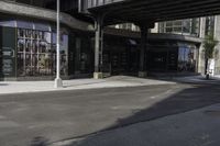 an empty street under a bridge that connects two buildings to the sidewalk and a sidewalk