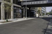 an empty street under a bridge that connects two buildings to the sidewalk and a sidewalk