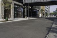 an empty street under a bridge that connects two buildings to the sidewalk and a sidewalk