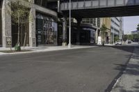 an empty street under a bridge that connects two buildings to the sidewalk and a sidewalk