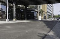 an empty street under a bridge that connects two buildings to the sidewalk and a sidewalk