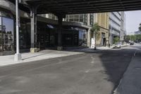 an empty street under a bridge that connects two buildings to the sidewalk and a sidewalk