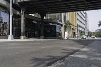 an empty street under a bridge that connects two buildings to the sidewalk and a sidewalk