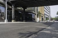 an empty street under a bridge that connects two buildings to the sidewalk and a sidewalk