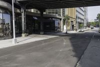 an empty street under a bridge that connects two buildings to the sidewalk and a sidewalk