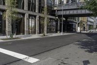 an empty street under a bridge that connects two buildings to the sidewalk and a sidewalk