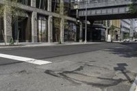 an empty street under a bridge that connects two buildings to the sidewalk and a sidewalk