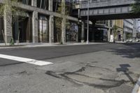 an empty street under a bridge that connects two buildings to the sidewalk and a sidewalk