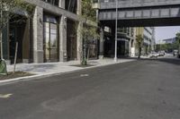 an empty street under a bridge that connects two buildings to the sidewalk and a sidewalk