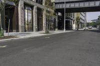 an empty street under a bridge that connects two buildings to the sidewalk and a sidewalk