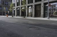 an empty street under a bridge that connects two buildings to the sidewalk and a sidewalk