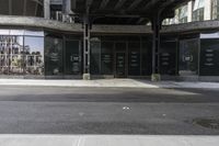 an empty street under a bridge that connects two buildings to the sidewalk and a sidewalk