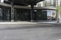 an empty street under a bridge that connects two buildings to the sidewalk and a sidewalk