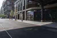 an empty street under a bridge that connects two buildings to the sidewalk and a sidewalk