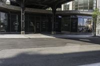 an empty street under a bridge that connects two buildings to the sidewalk and a sidewalk