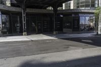 an empty street under a bridge that connects two buildings to the sidewalk and a sidewalk