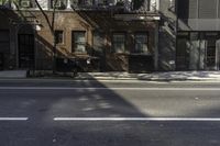 an empty street in an urban area with several buildings near it, including a red fire hydrant