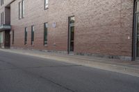 an empty street next to an apartment building with tall windows in front of it and a red fire hydrant on one side and an open door