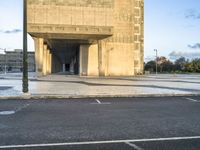 the empty street of an urban city with no people around it, with a sign indicating that the entrance is to a building