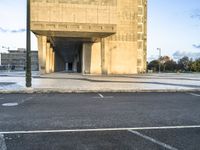 the empty street of an urban city with no people around it, with a sign indicating that the entrance is to a building