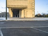 the empty street of an urban city with no people around it, with a sign indicating that the entrance is to a building