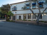 an empty street in front of an apartment complex with many windows in the middle of it