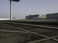 an empty street, two empty parking spaces next to an empty warehouse building with a large advertisement on the side of it