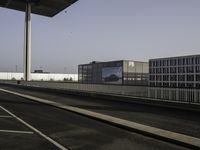 an empty street, two empty parking spaces next to an empty warehouse building with a large advertisement on the side of it