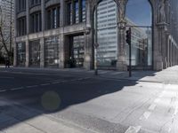 empty streets in front of a skyscraper in london, england by an intersection with traffic lights and traffic signals