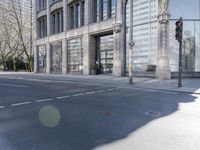 empty streets in front of a skyscraper in london, england by an intersection with traffic lights and traffic signals