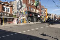 a street is littered with graffiti painted stores and small businesses that are vacant and empty