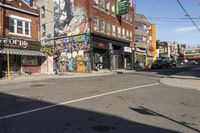 a street is littered with graffiti painted stores and small businesses that are vacant and empty