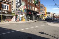 a street is littered with graffiti painted stores and small businesses that are vacant and empty