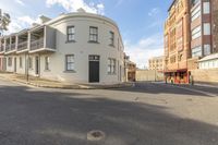 an empty road with no traffic and brick buildings in the background and a circular building