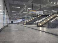 an empty subway with multiple steps down and no people around it as well as a banner about how to go