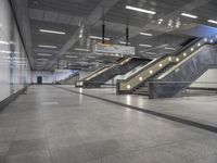 an empty subway with multiple steps down and no people around it as well as a banner about how to go