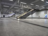 an empty subway with multiple steps down and no people around it as well as a banner about how to go