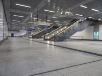 an empty subway with multiple steps down and no people around it as well as a banner about how to go