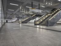 an empty subway with multiple steps down and no people around it as well as a banner about how to go