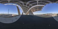 the image shows a photo taken in 360 - view of an empty tennis court near a beach