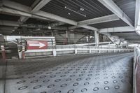 an empty and empty train station with signs in it and an arrow in the middle of the floor