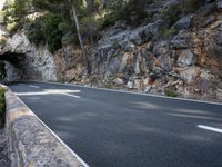a tunnel in the middle of the mountain next to the road is empty but there is no traffic